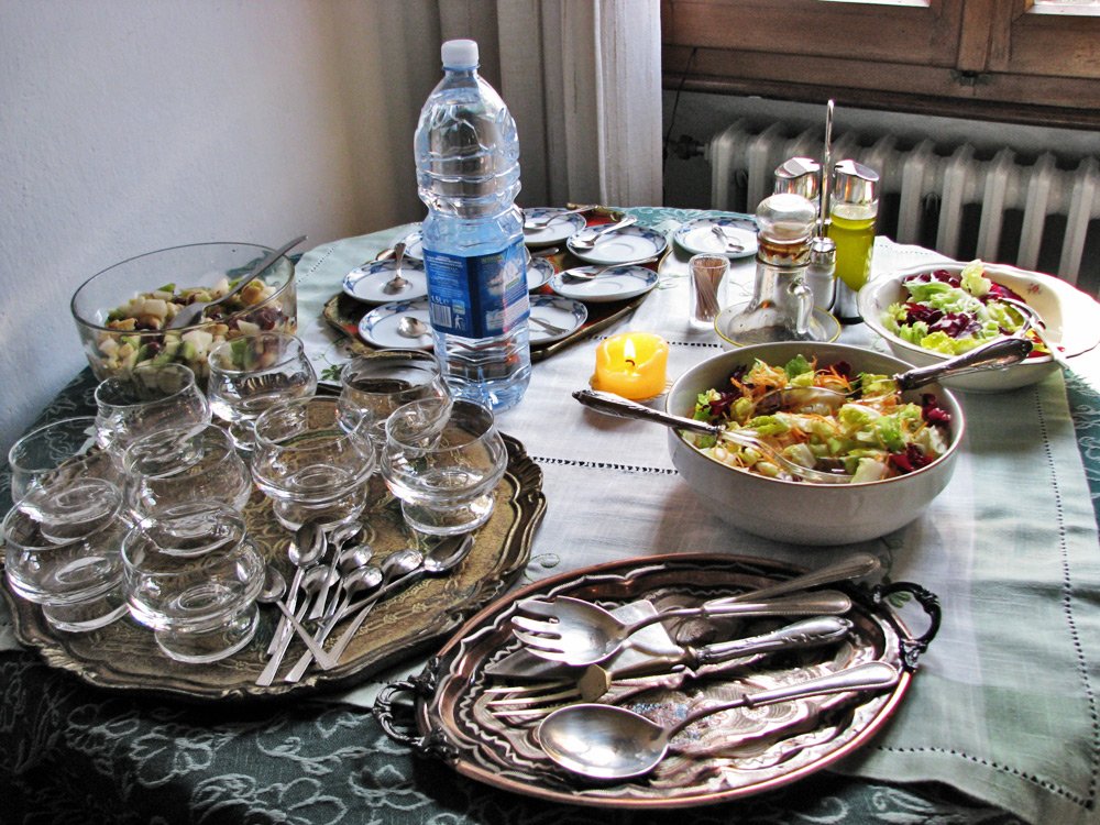a table set for several people with silverware, bowls and glasses