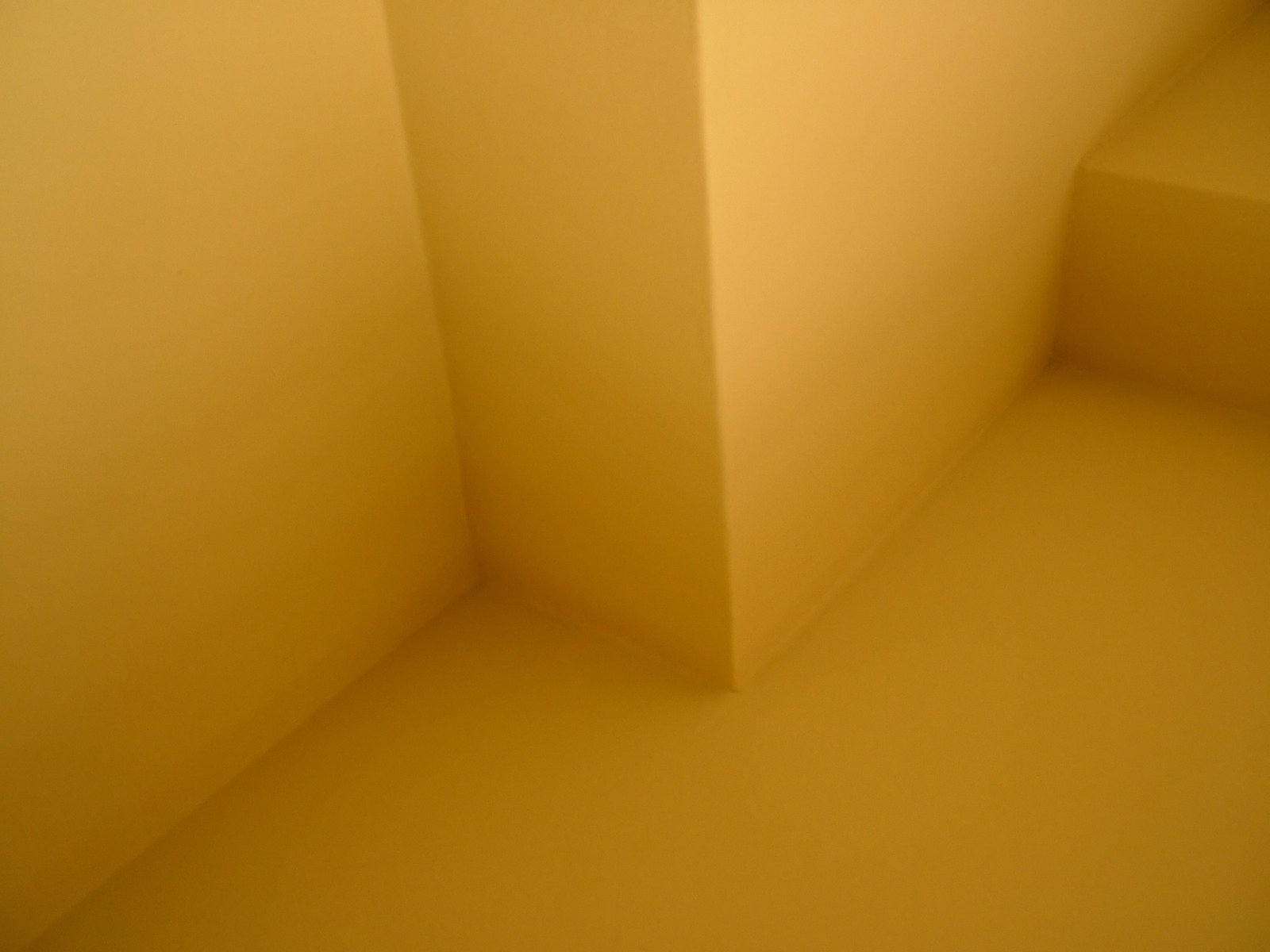 a white corner on the wall with light coming through