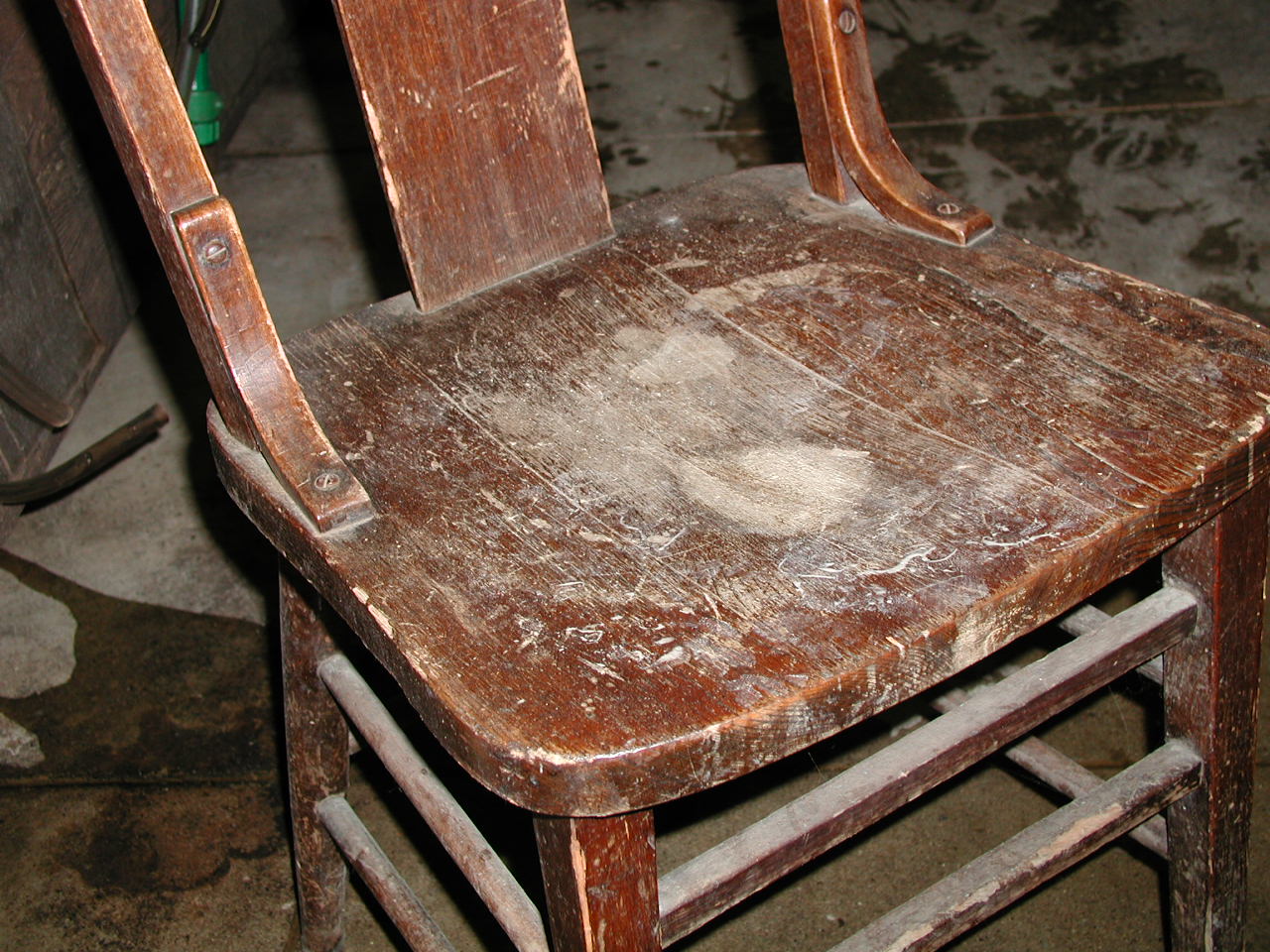 a worn wooden chair on a dark background