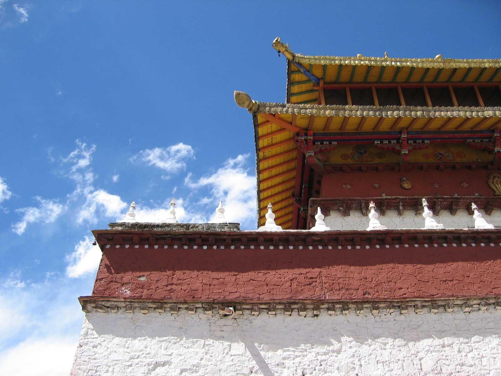 a red and yellow building with clouds in the background