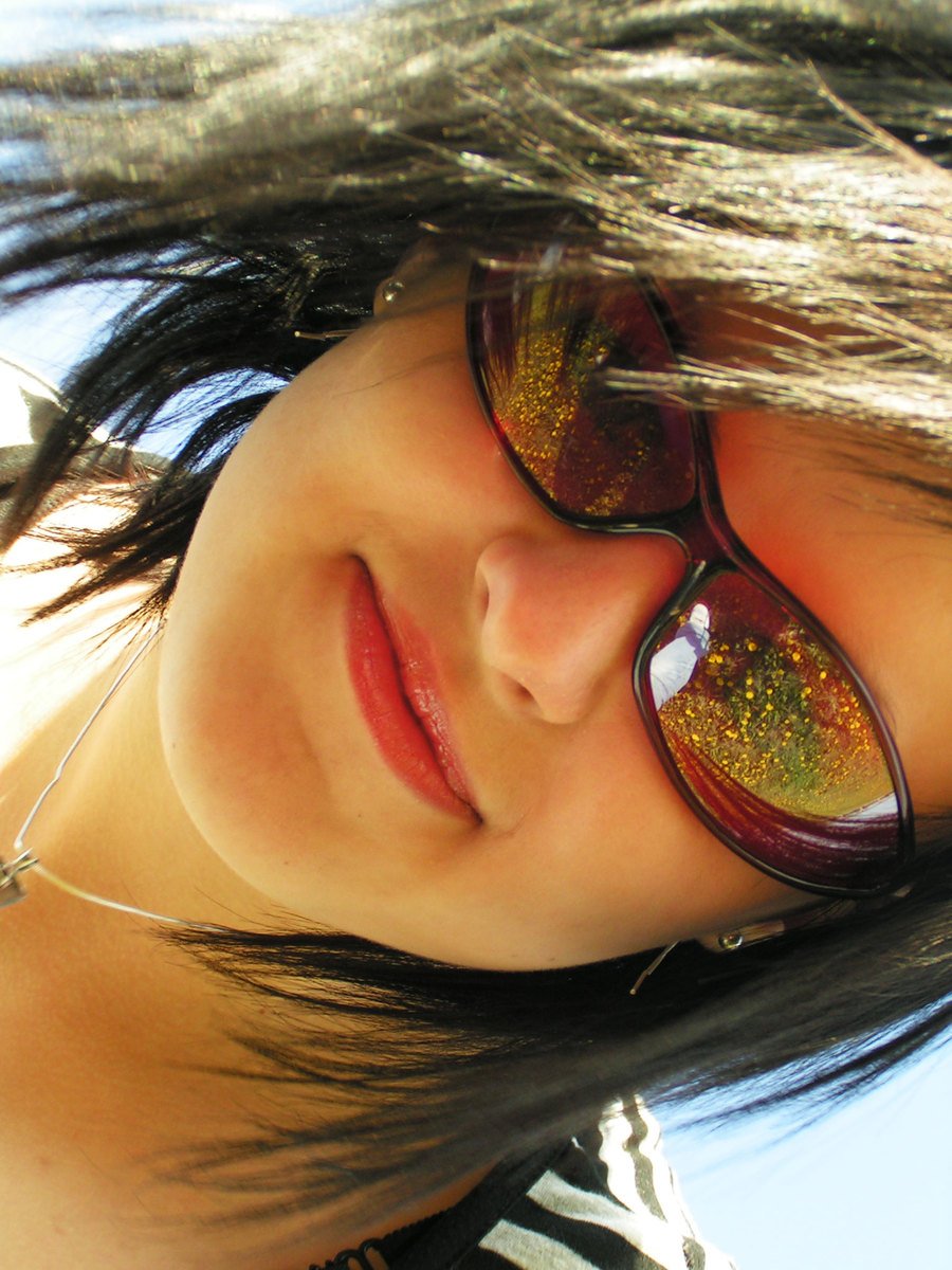 a woman wearing glasses with sun reflection on her eye