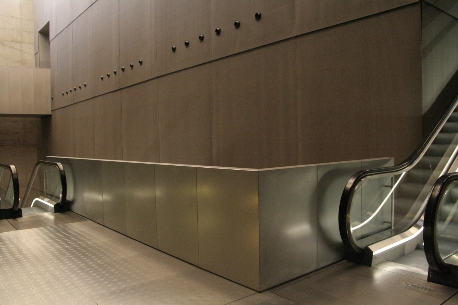 three escalators are seen in this indoor area