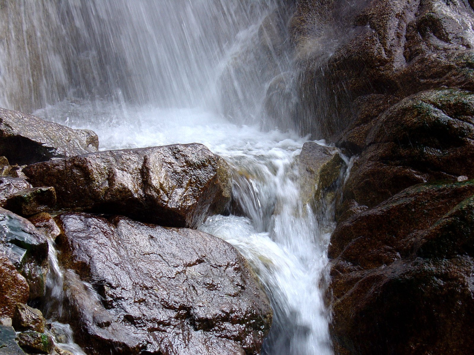 a small waterfall is shown in a rocky area