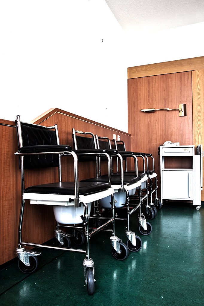 a row of chairs next to a refrigerator in an office