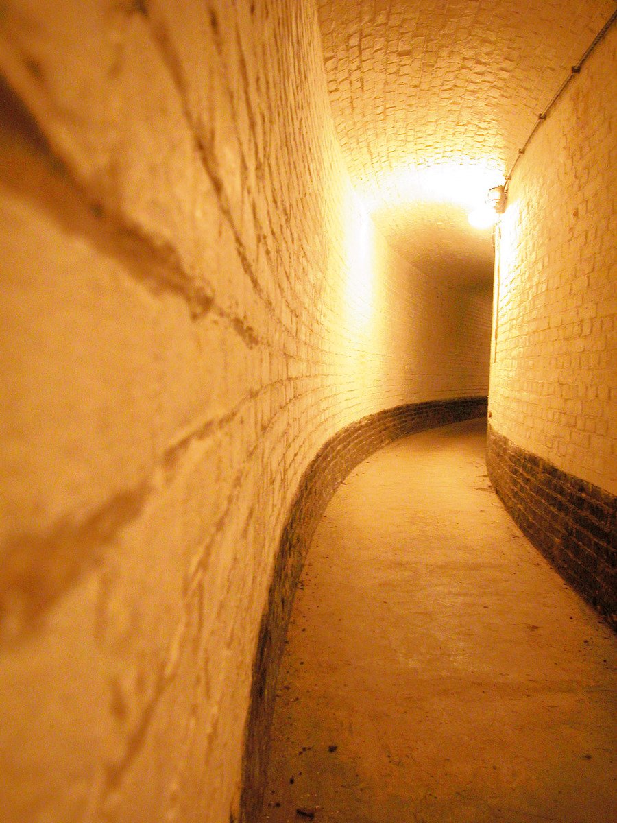a long dimly lit hallway with a few light in it