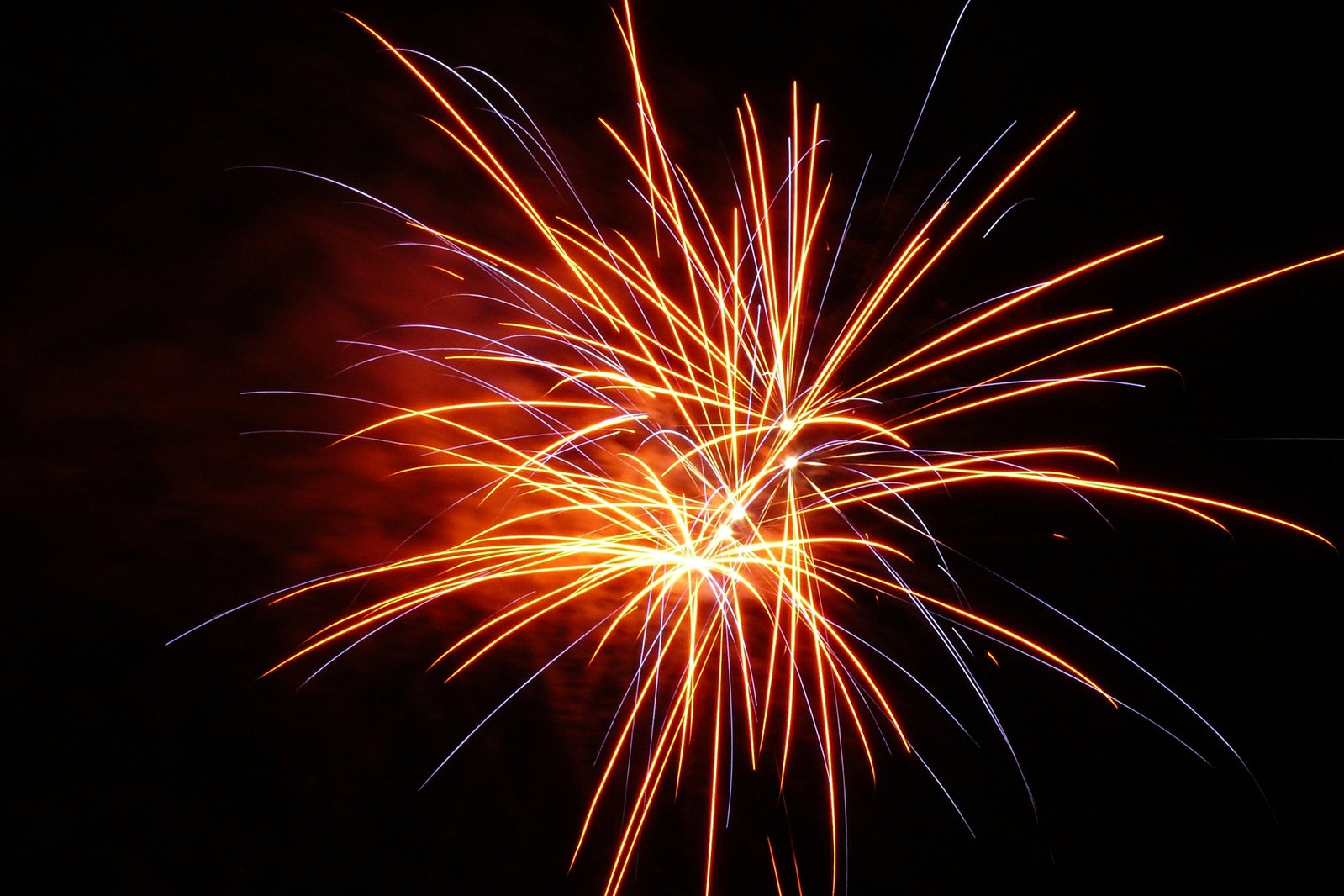 colorful fireworks exploding into the night sky with orange and blue colors