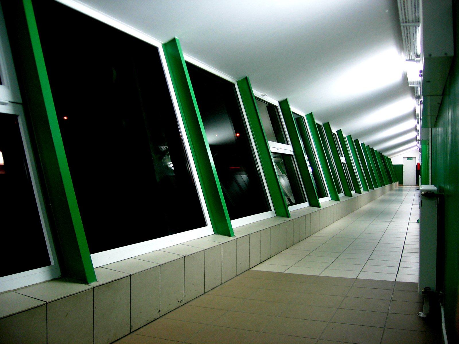 the green and white panels line the wall along an alley