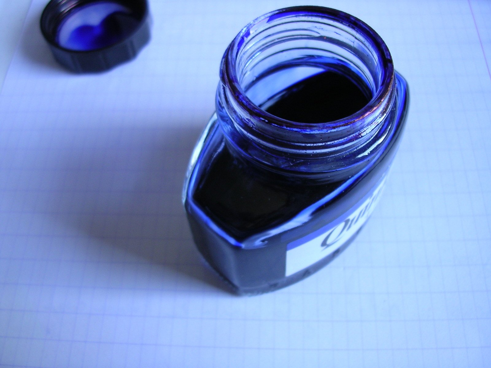 a jar filled with blue liquid sitting on top of a table