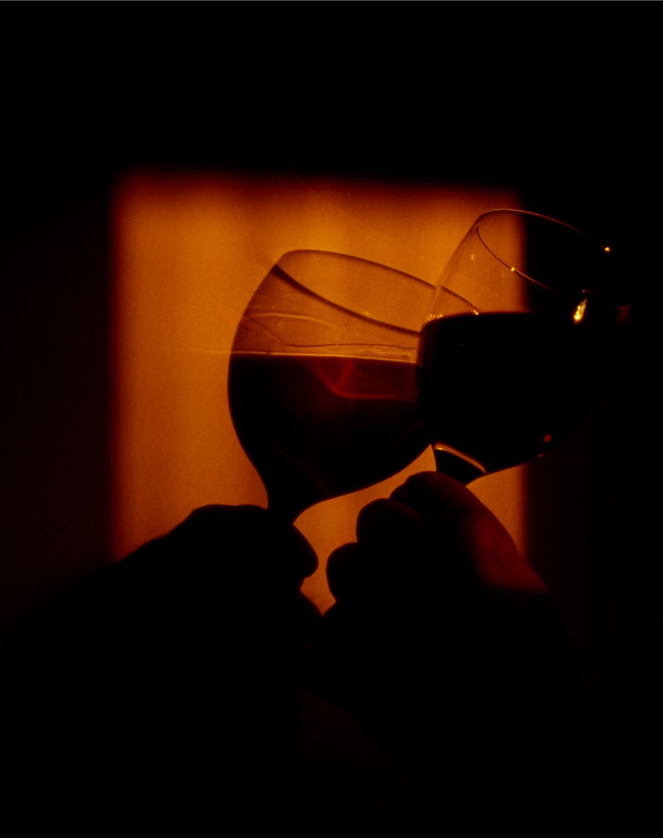 the person is drinking wine in a glass