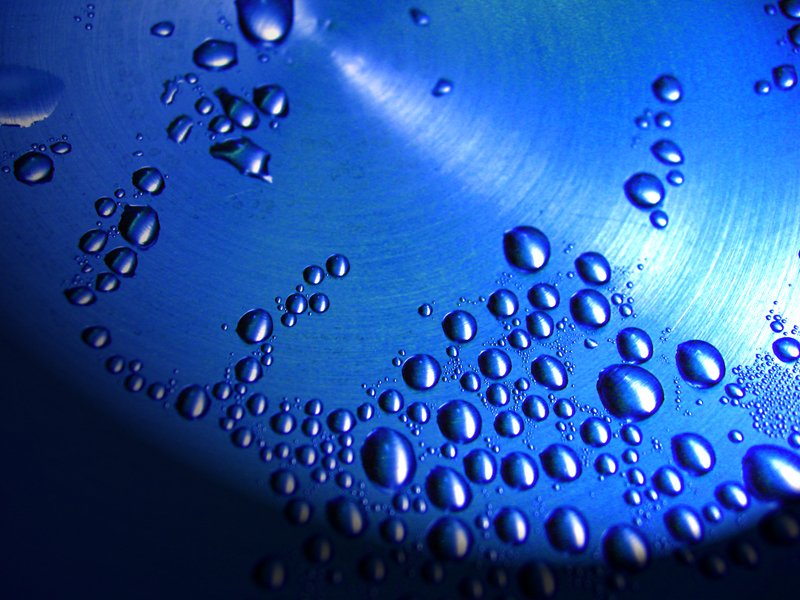 a blue plate with several bubbles of water on it