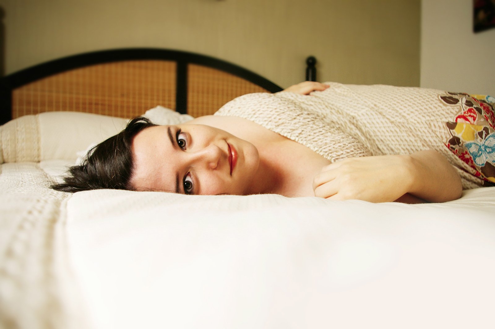 a woman laying on top of a white bed
