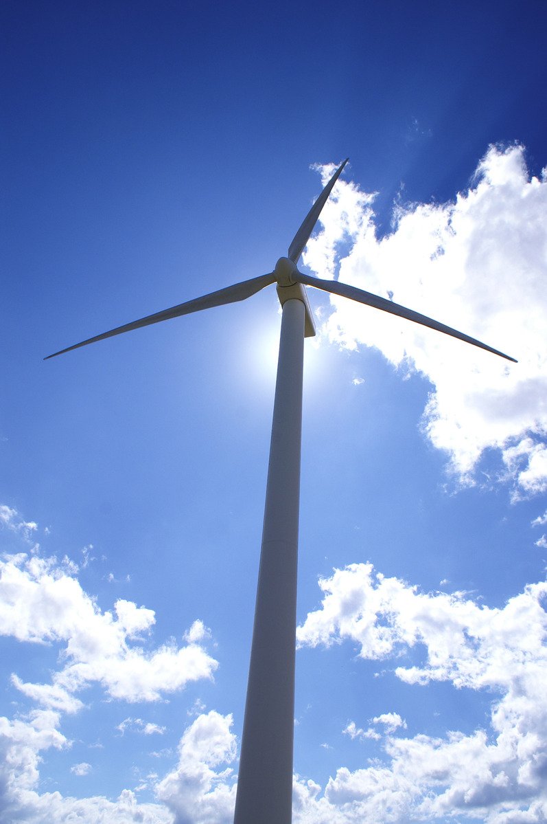 a wind turbine under a bright blue sky