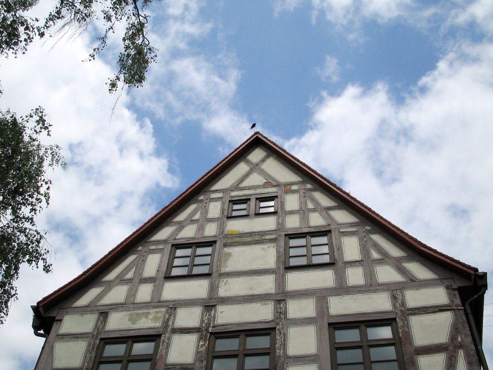 the top half of an old building under a cloudy blue sky