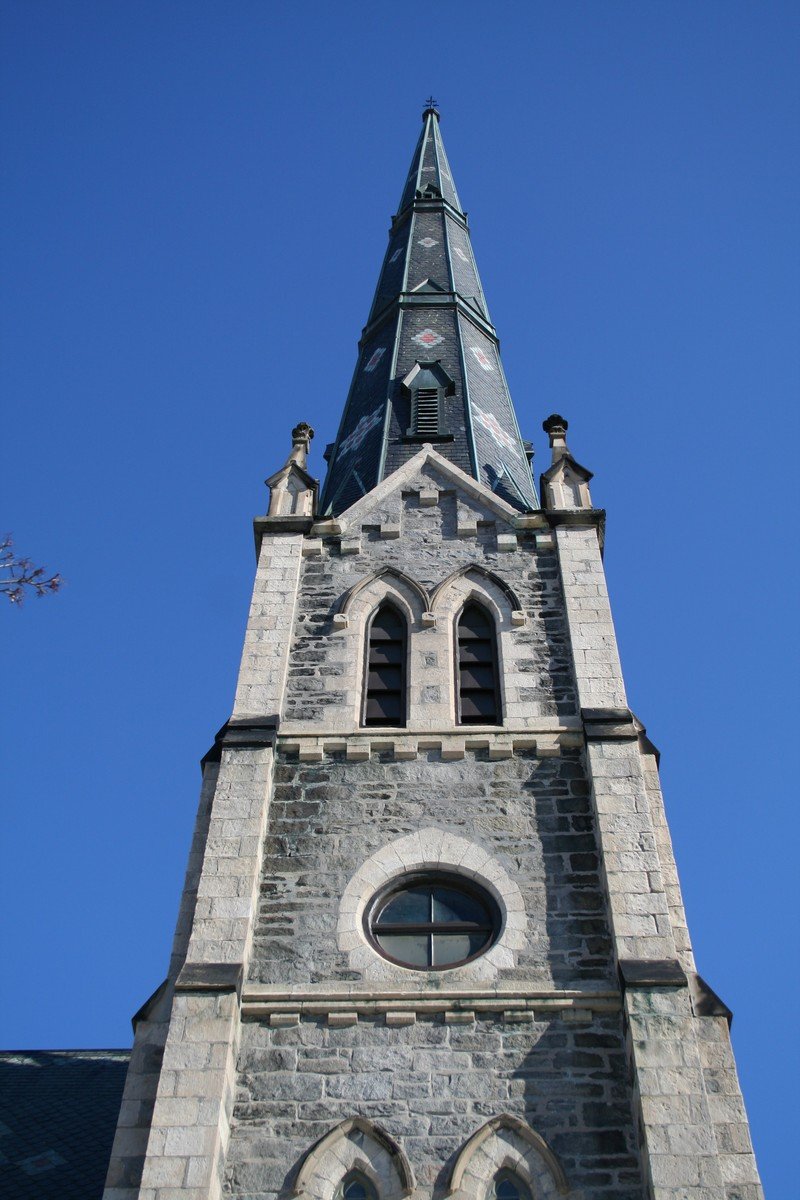 a church steeple with two large bells at the top and an inverted window