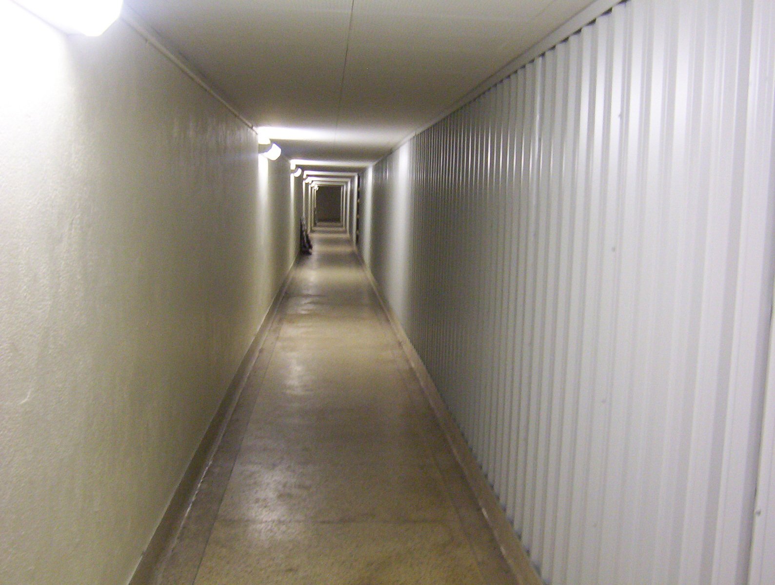 a very narrow hallway with long white walls