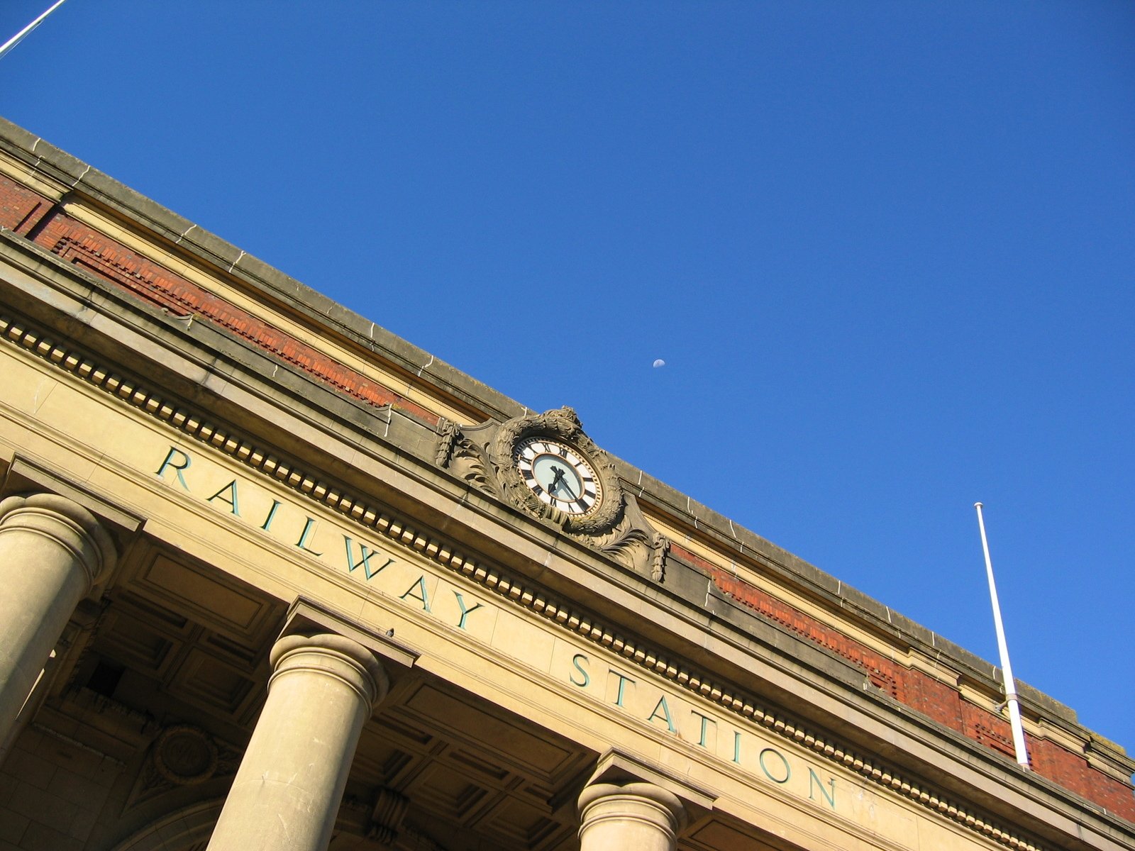 a large building has pillars and a clock on it