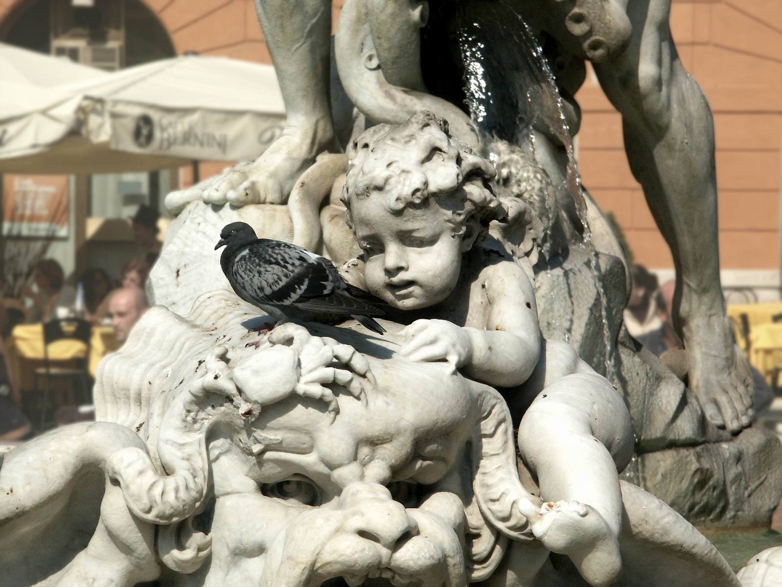 a fountain with a statue and a bird in it