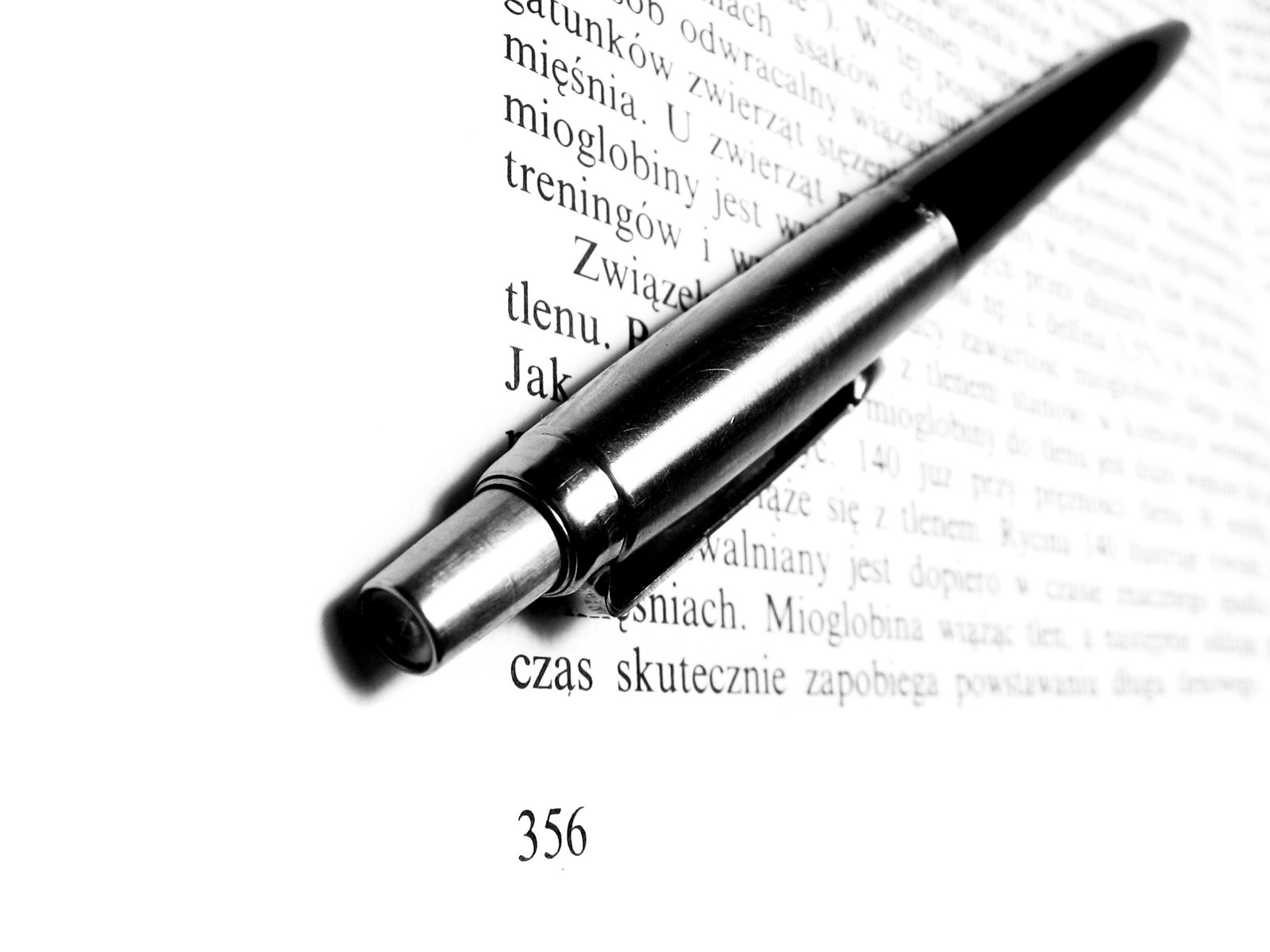 black pen laying on top of a page of a text description
