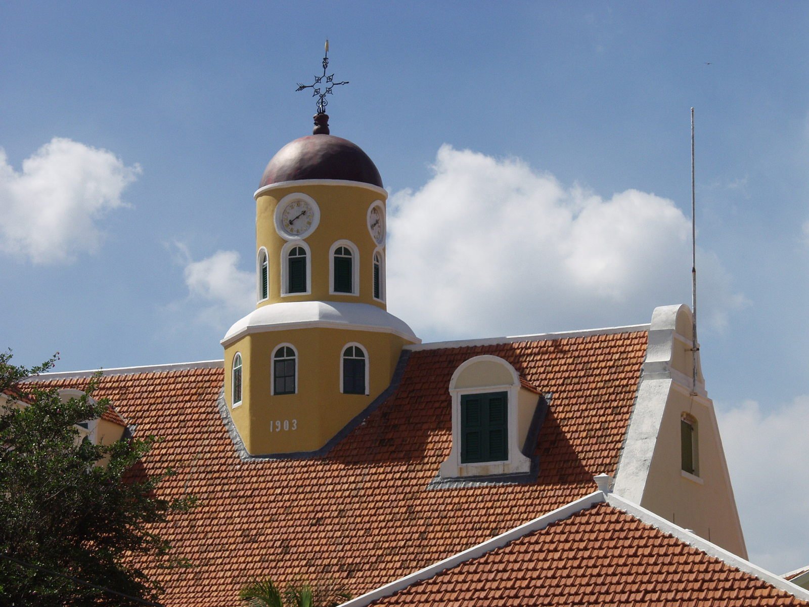 an ornate yellow and white church building with red roof