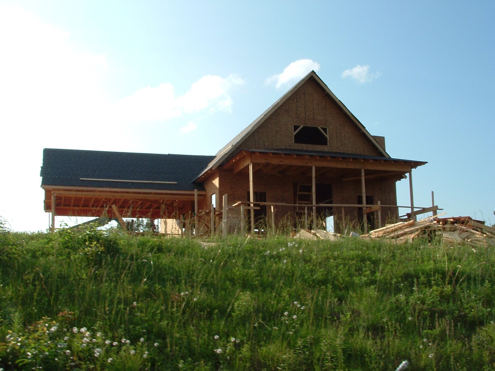 a house that is in the grass under construction