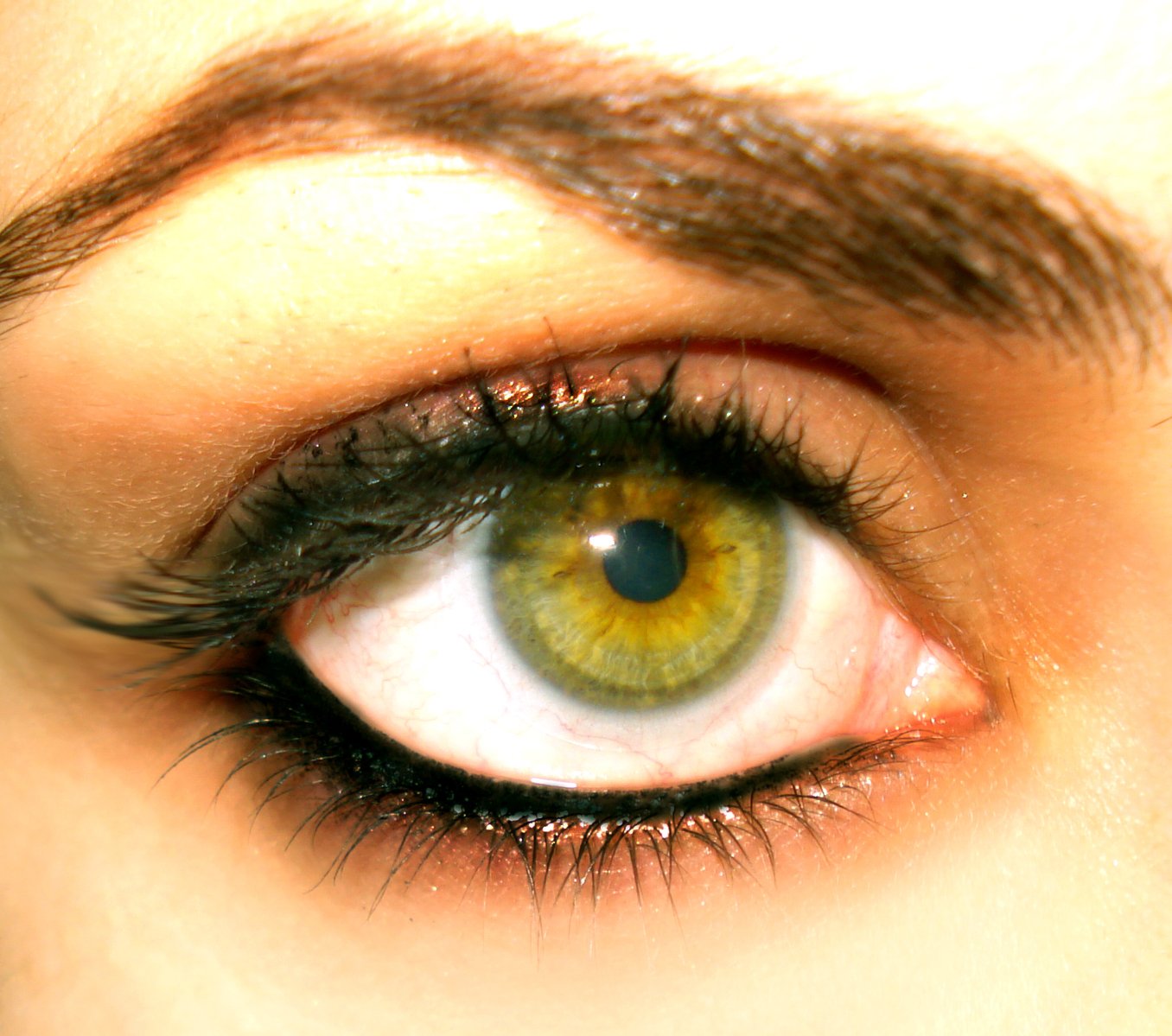 a persons eye with green and yellow eyeshadow