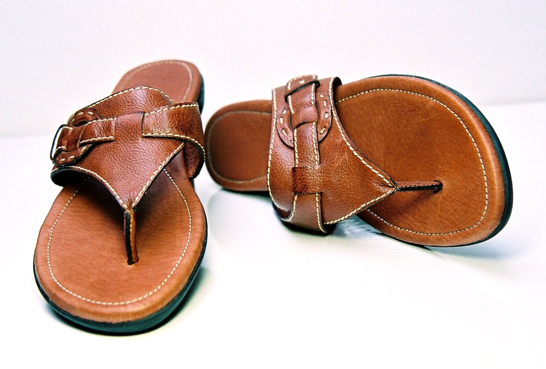 the sandals are tied together on a white table