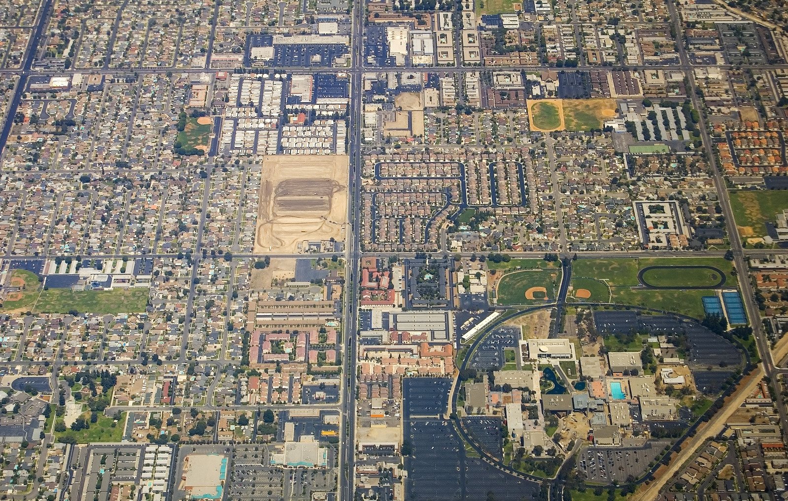 an aerial po of a city with lots of buildings and parking lot areas