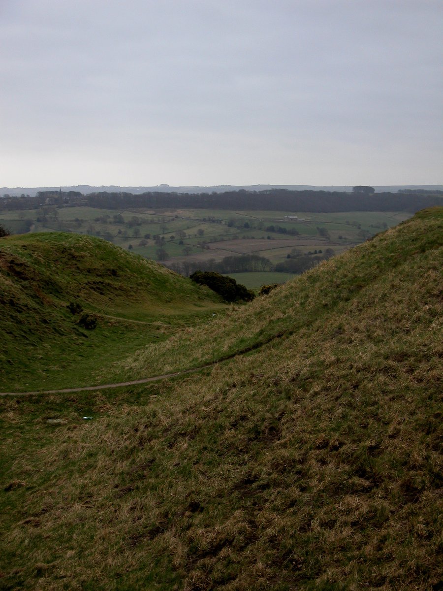 the hill has grass growing on it and many fields