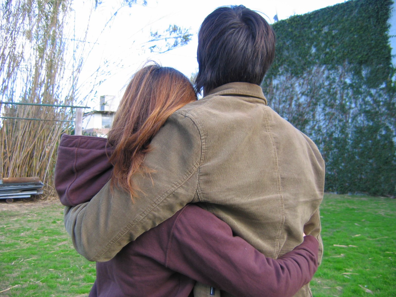 two people holding each other in their arms looking at soing