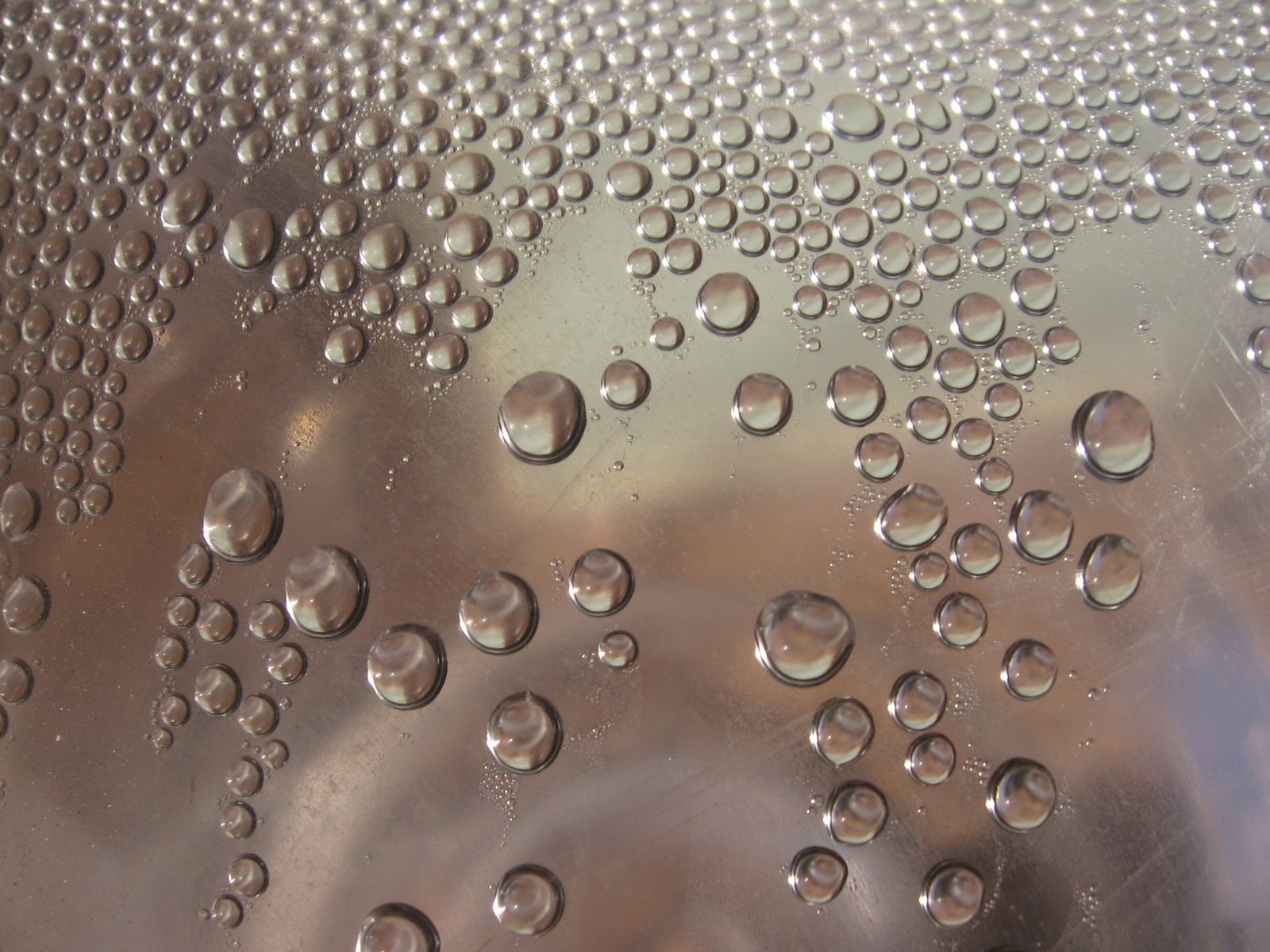 water drops on metallic surface, with one large window in the background