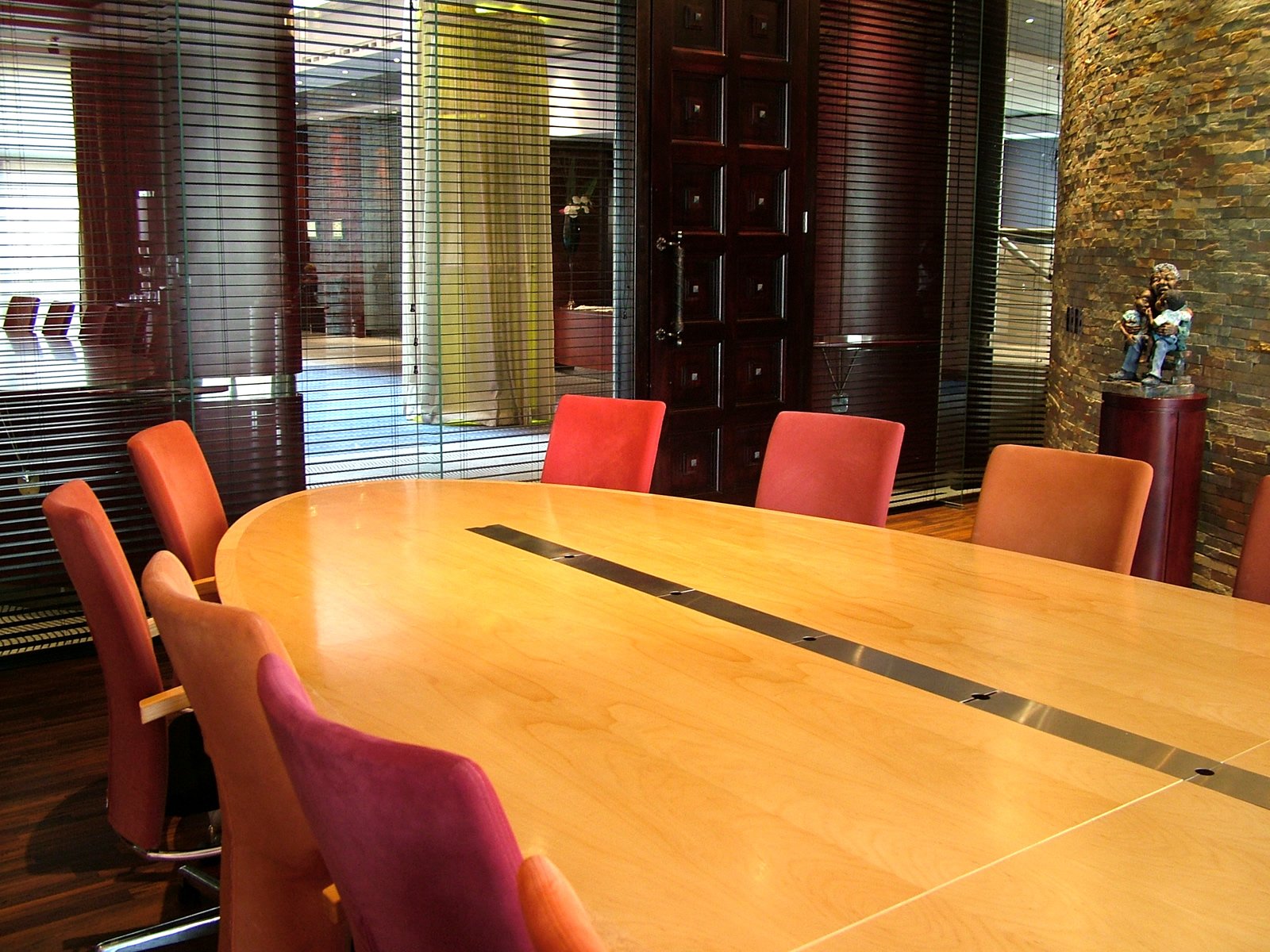 a big wooden table surrounded by orange chairs