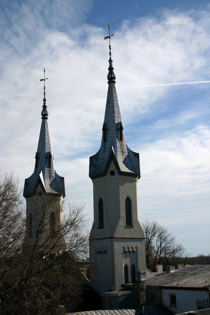 two tall, pointed towers with crosses over a rooftop