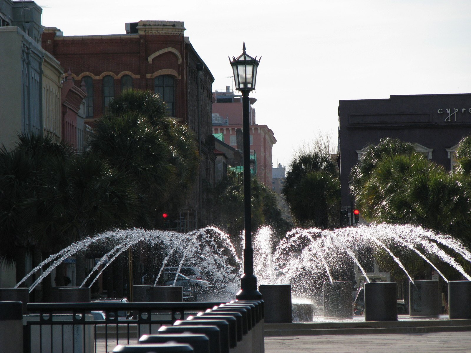 a row of water fountains spewing up in the city