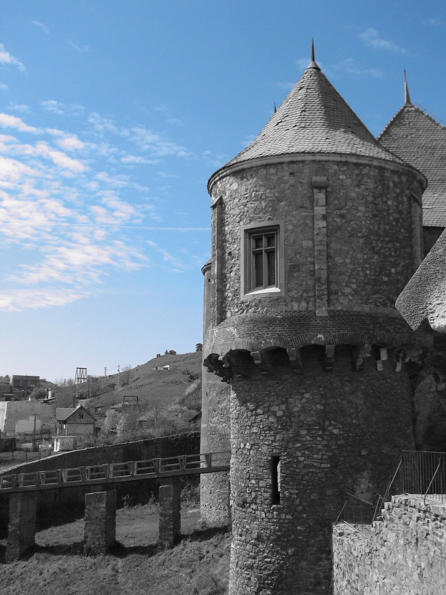 the old building with two large towers sits next to the bridge