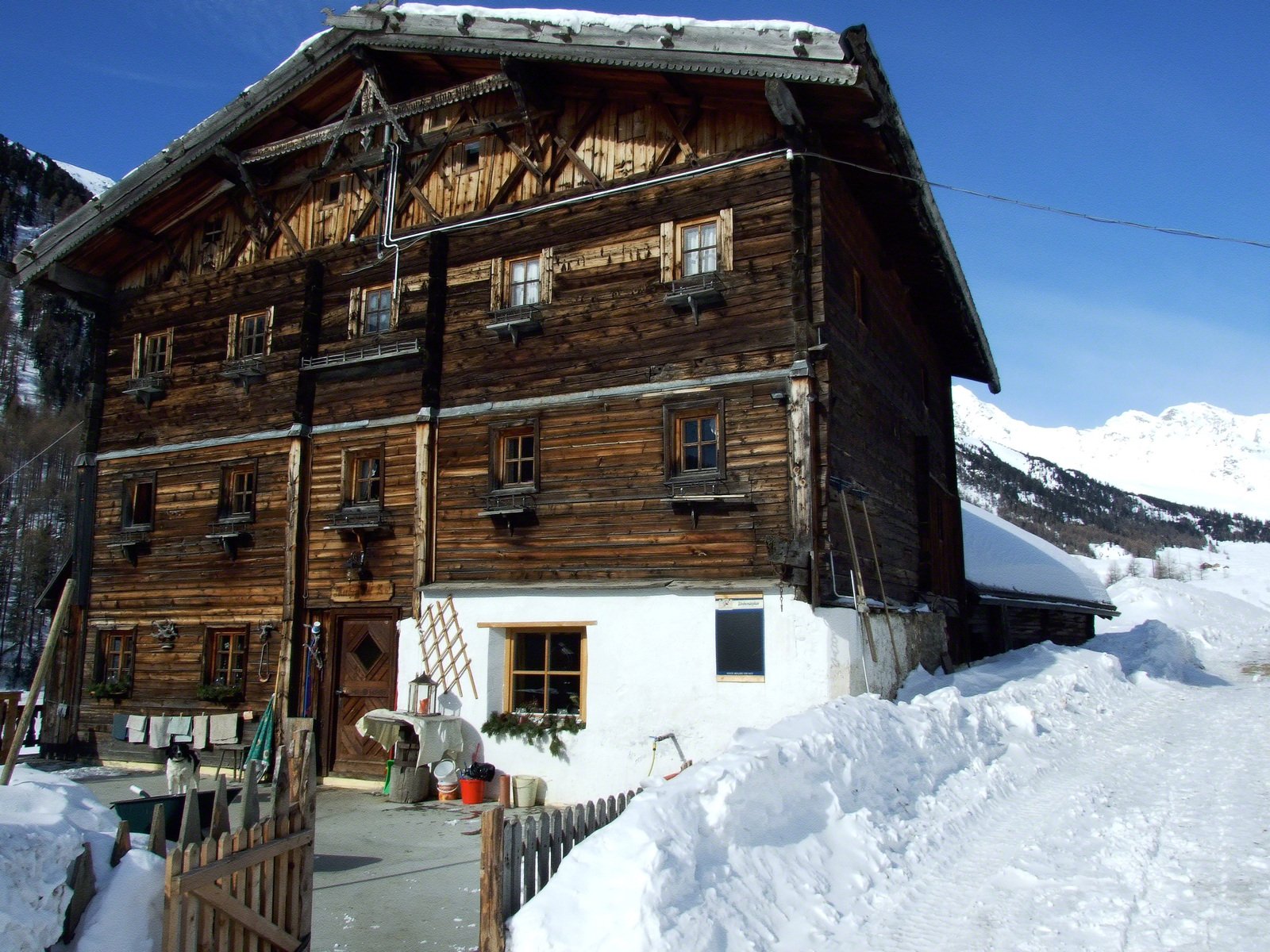 a house in the mountains with snow on the ground