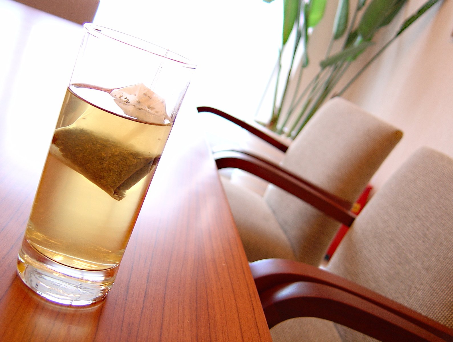 a glass filled with liquid next to a wooden table