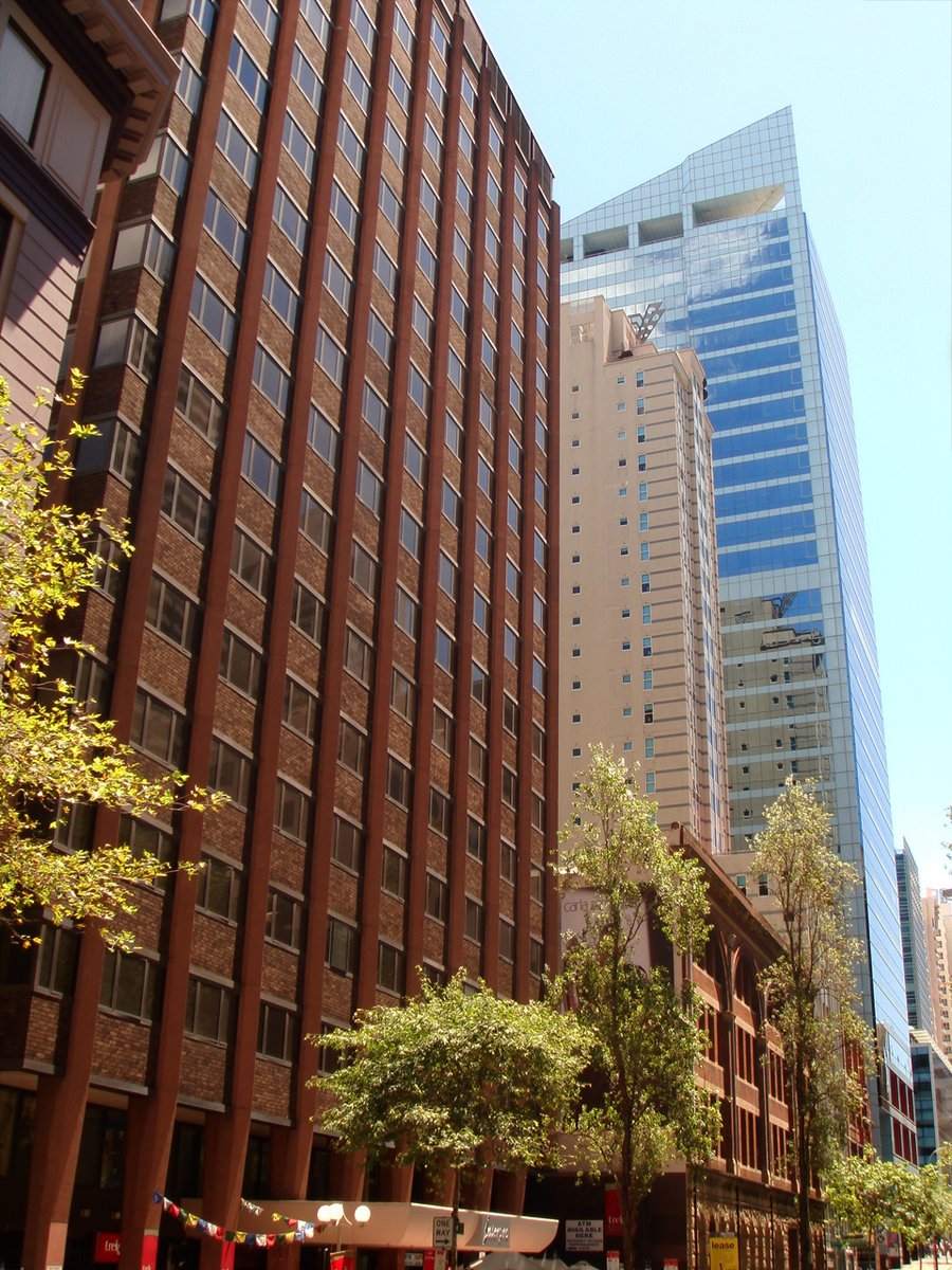 the street is lined with tall buildings near the trees