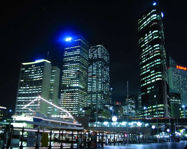 a night time scene of a city at a marina