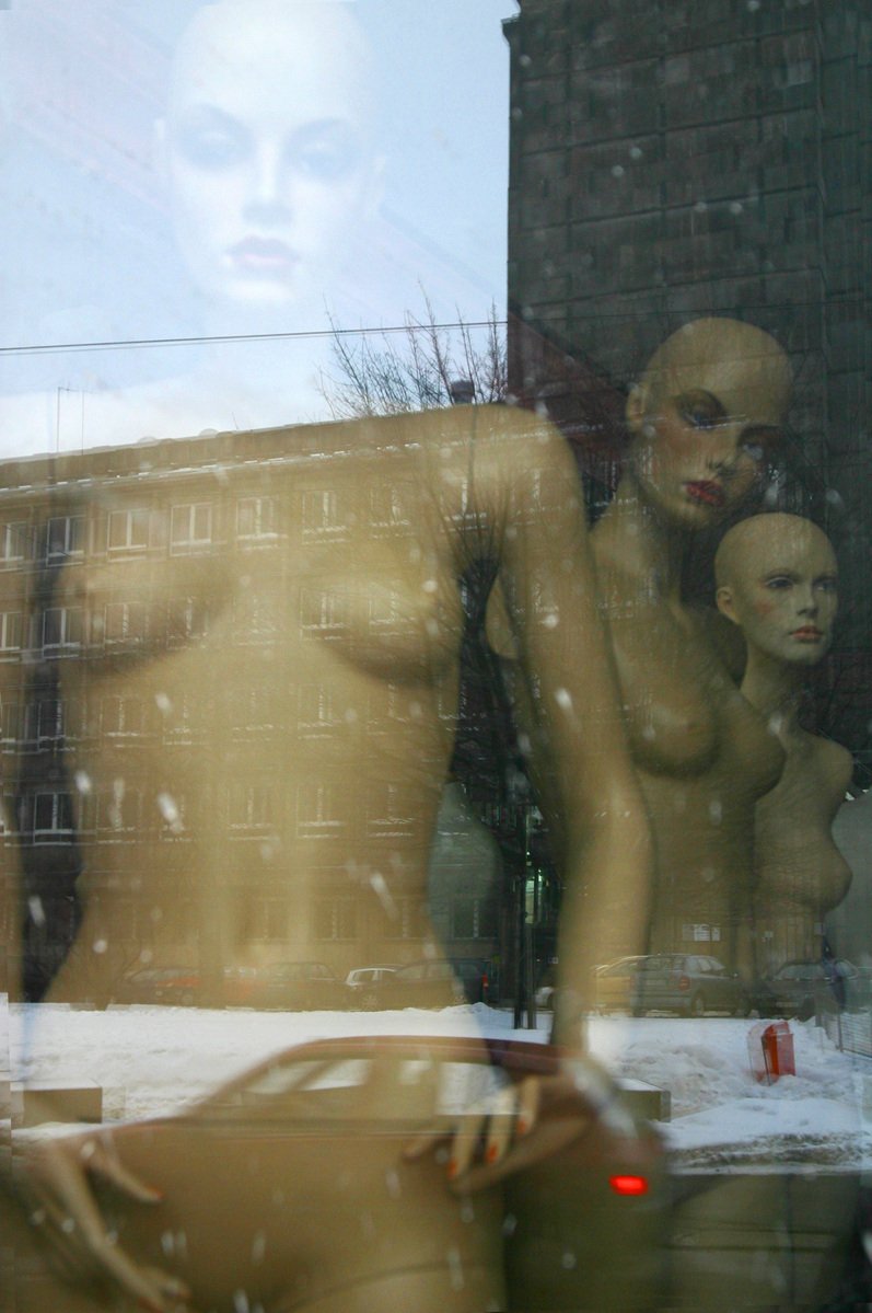 some  mannequins in a window behind a glass