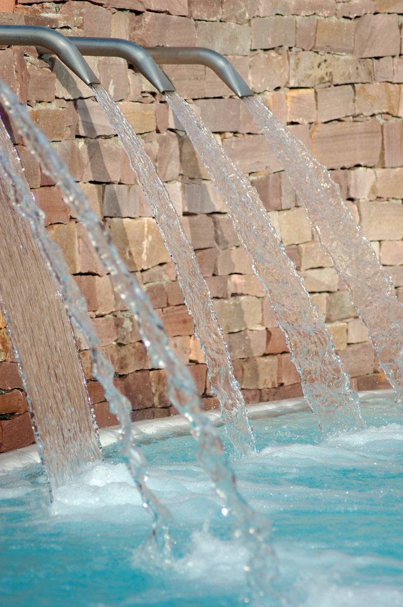 three spray jets running over the side of a swimming pool