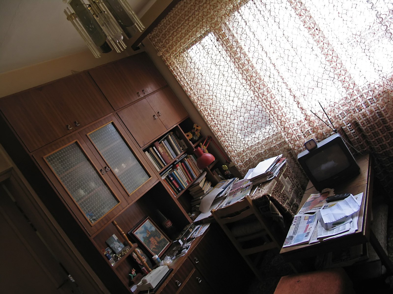 a wooden desk and bookcase in front of a window