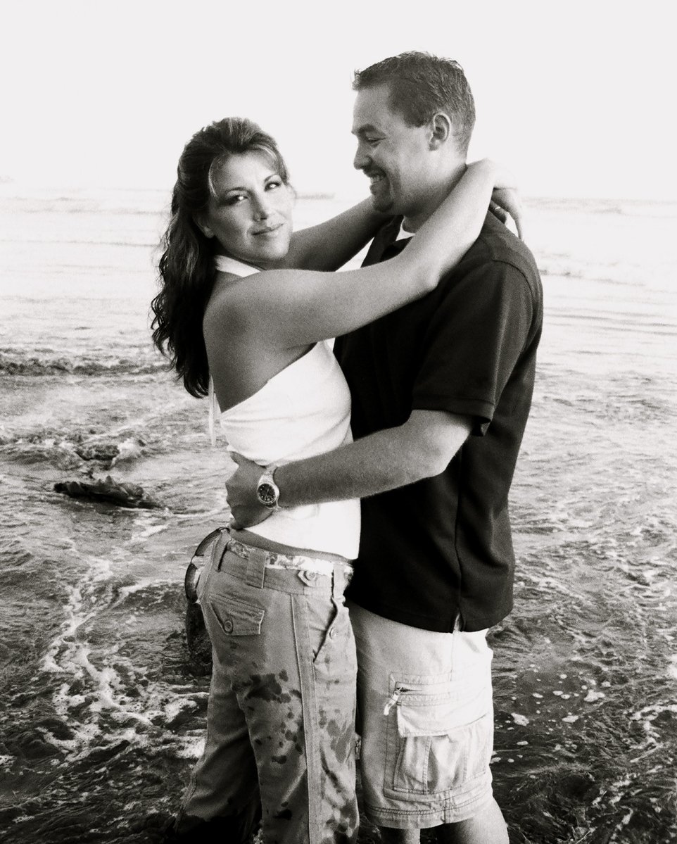 a man and a woman hugging by the water