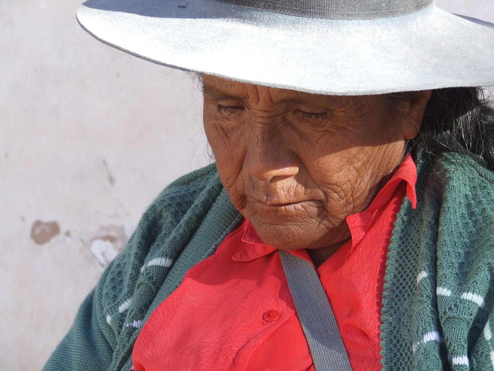 an old woman with a white hat standing outdoors
