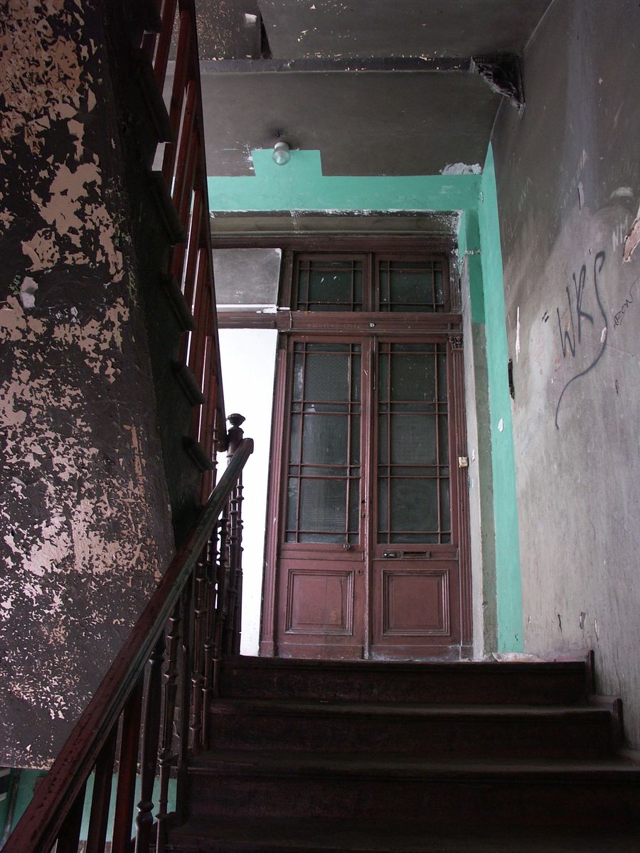 this is a stairway with no door, with graffiti on the walls and stairs