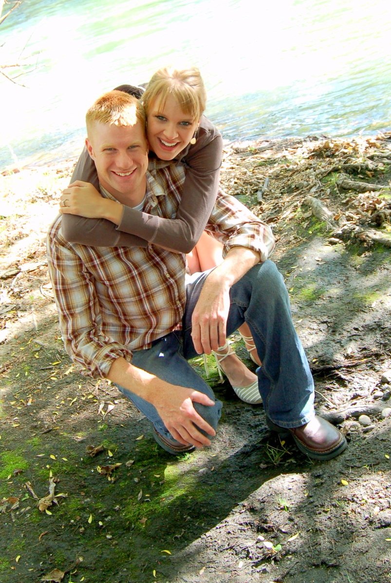 there is a man hugging a woman by the water