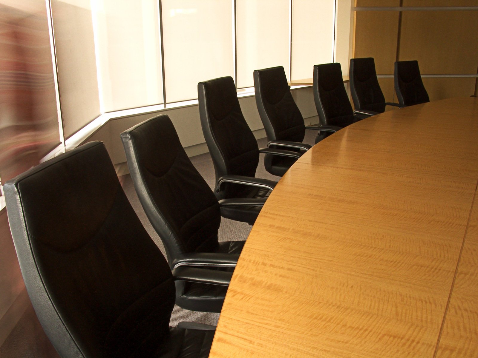 the office conference table has black chairs