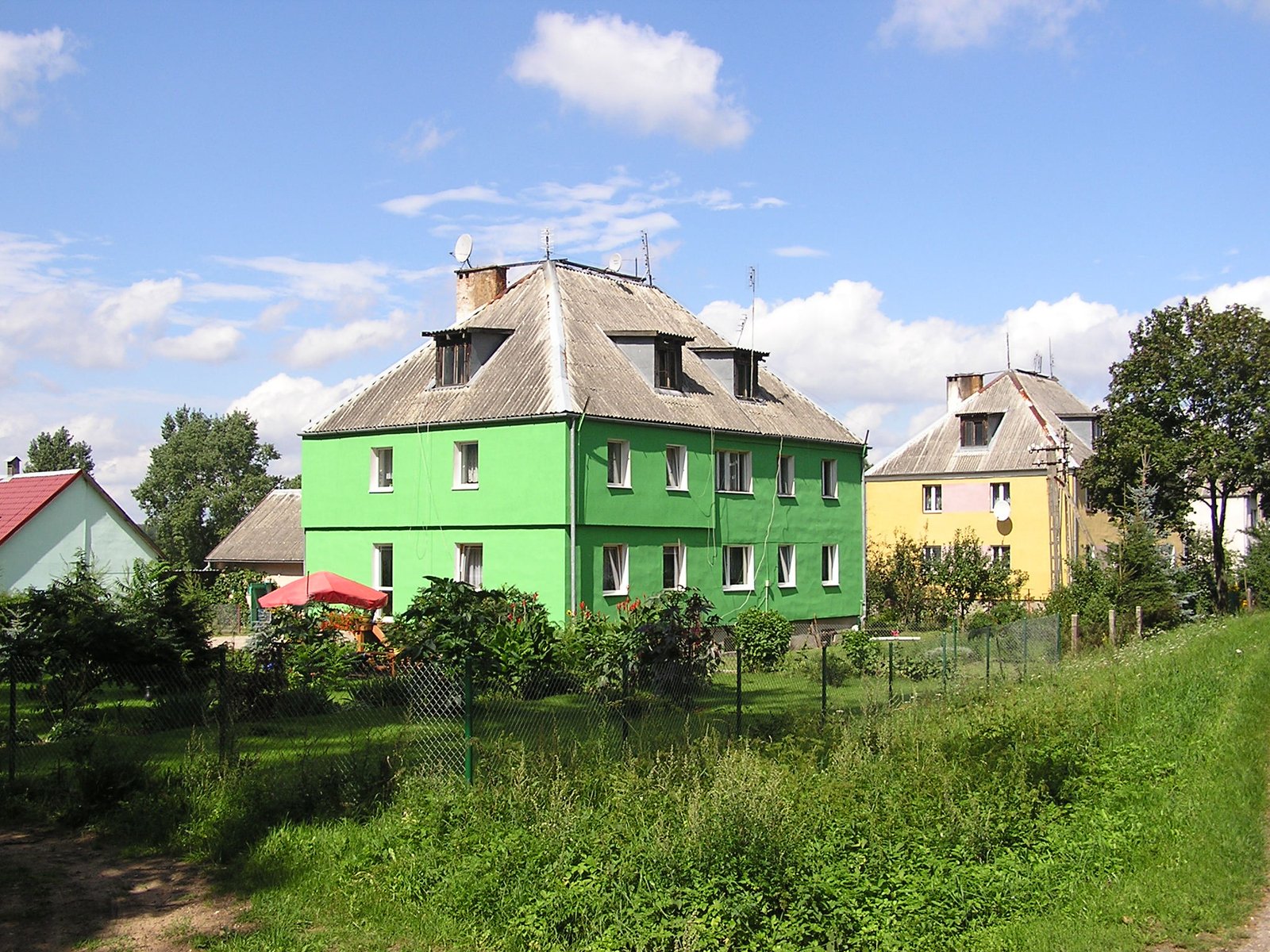 a fence in front of a green house