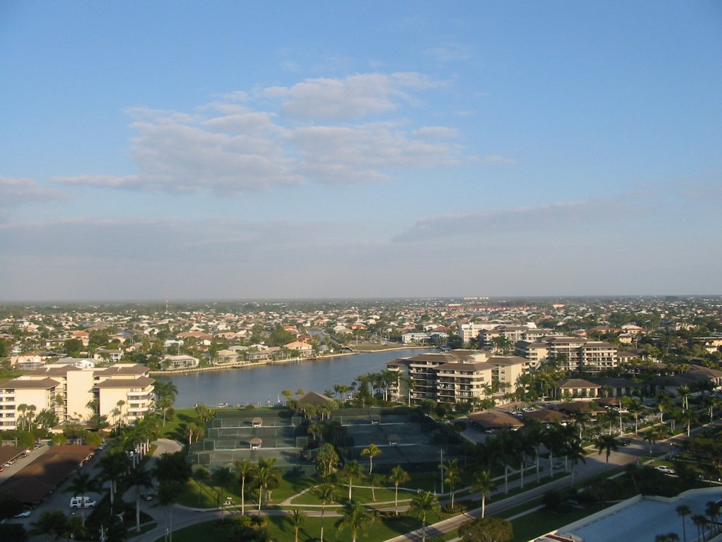 a clear blue sky with white clouds and some water