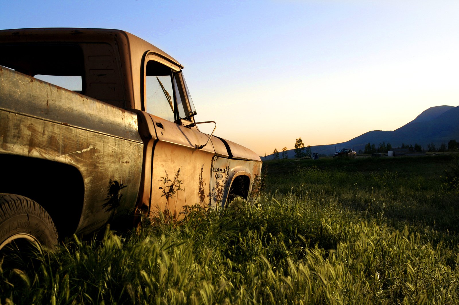 an old truck that is parked in the grass