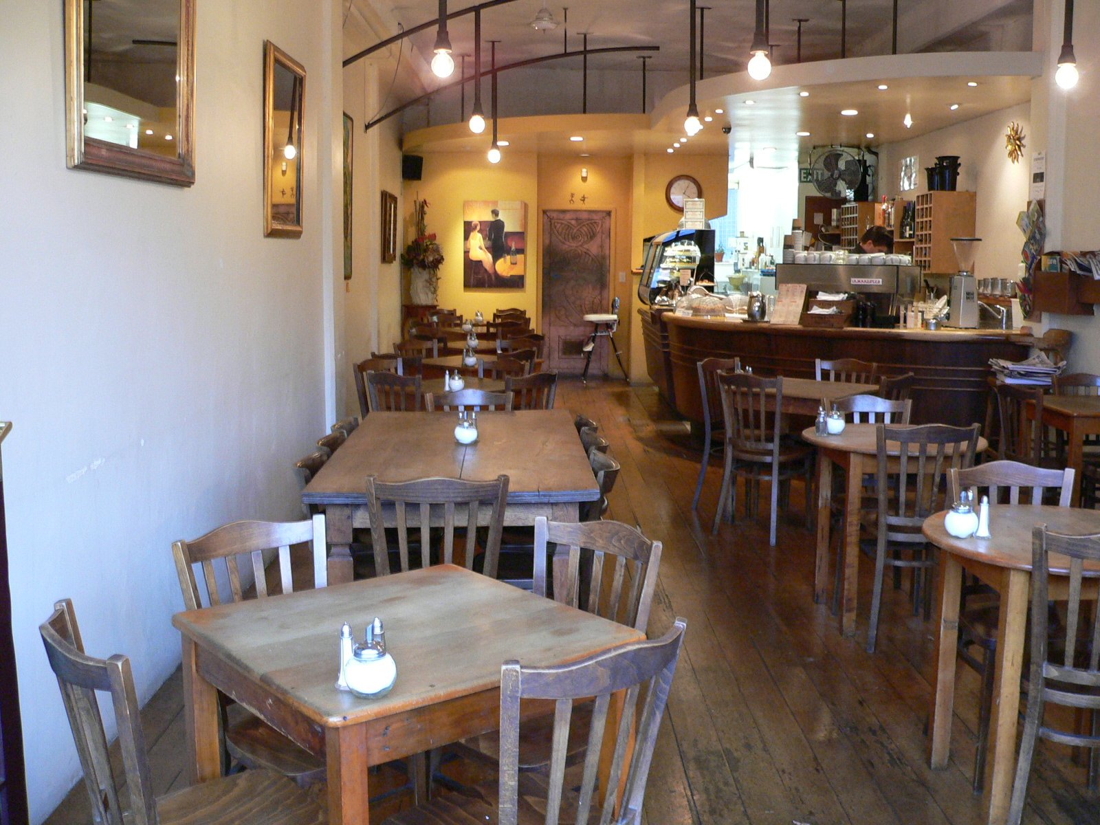 a room full of chairs and tables with wood floors